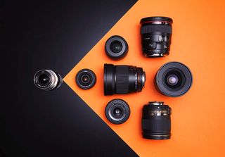 A selection of wide-angle prime lenses on an orange and black background