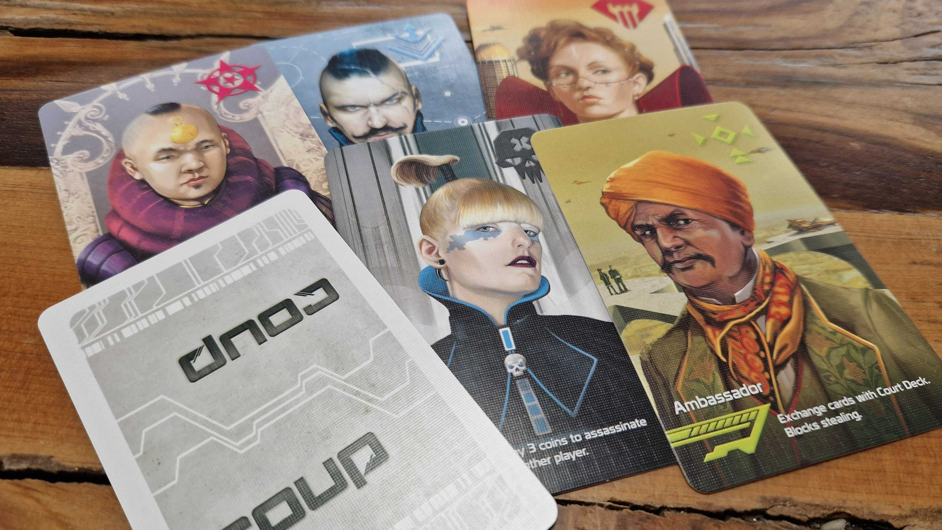 An array of noble cards from Coup, laid out in a spread on a wooden surface