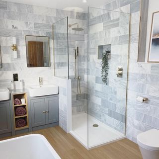 bathroom with grey tiles wall shower cabin wash basin and mirror