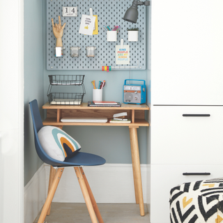 Desk situated in an alcove with wall mounted cupboards above and to the side.