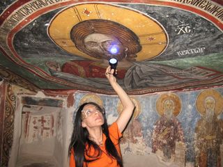 The researchers analyzed some of the paintings on site using various techniques, including infrared, ultraviolet and X-ray fluorescence imaging. Here, UCLA archaeologist Ioanna Kakoulli examines a painting in the monastery under UV light.