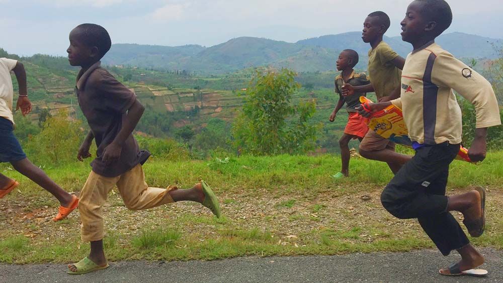 Fans run alongside the race convoy