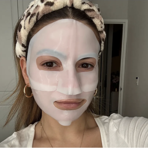 girl with brown hair and cheetah headband in a sheet mask