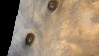 An aerial view of brown volcanoes on a sandy landscape