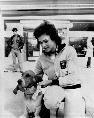 olympic athlete checks ID with mascot dog