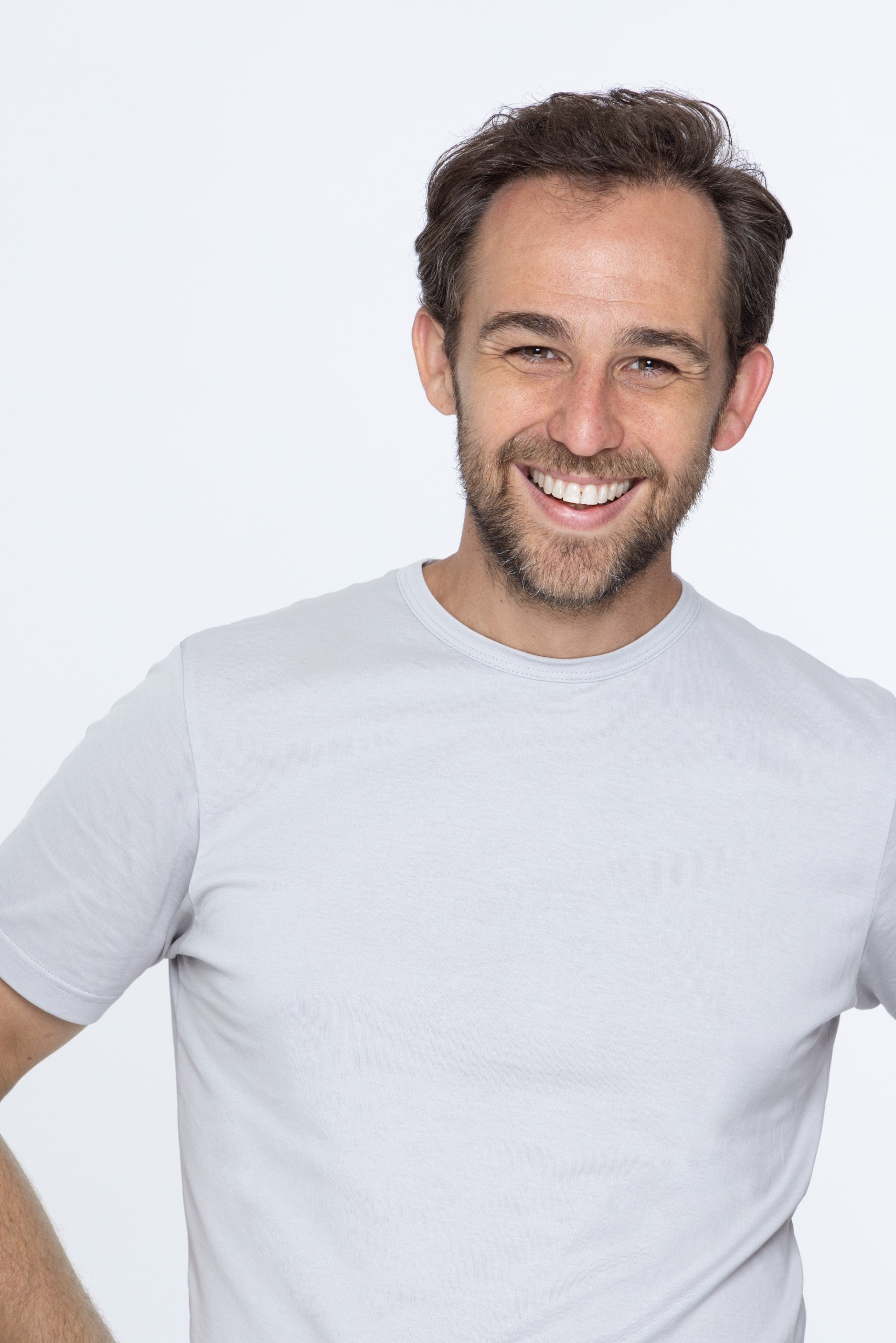 a white man with brown hair in a white t-shirt