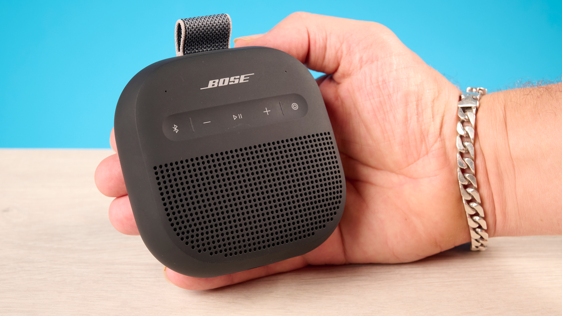 Bose SoundLink Micro 2 in black photographed in front of a blue background