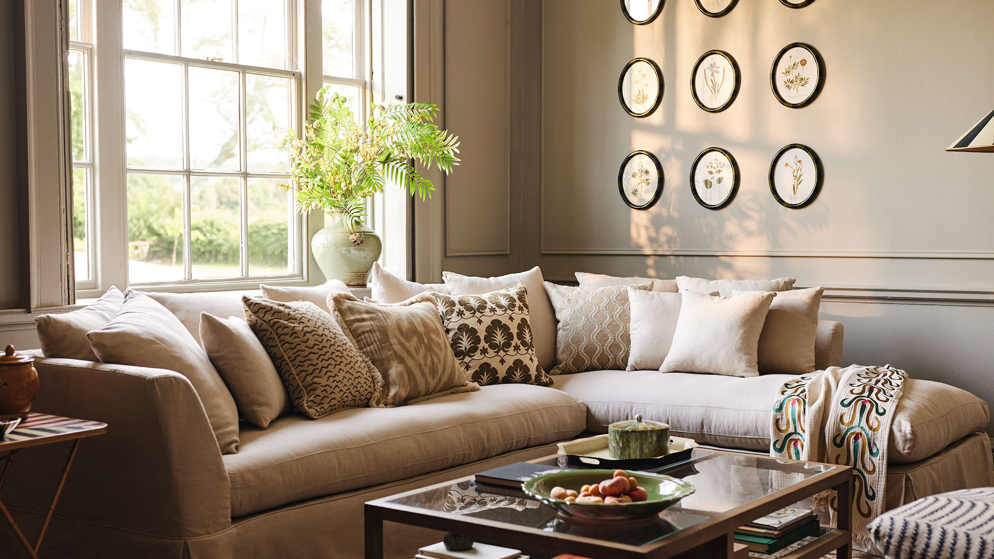 cosy neutral living room with sash window and corner sofa