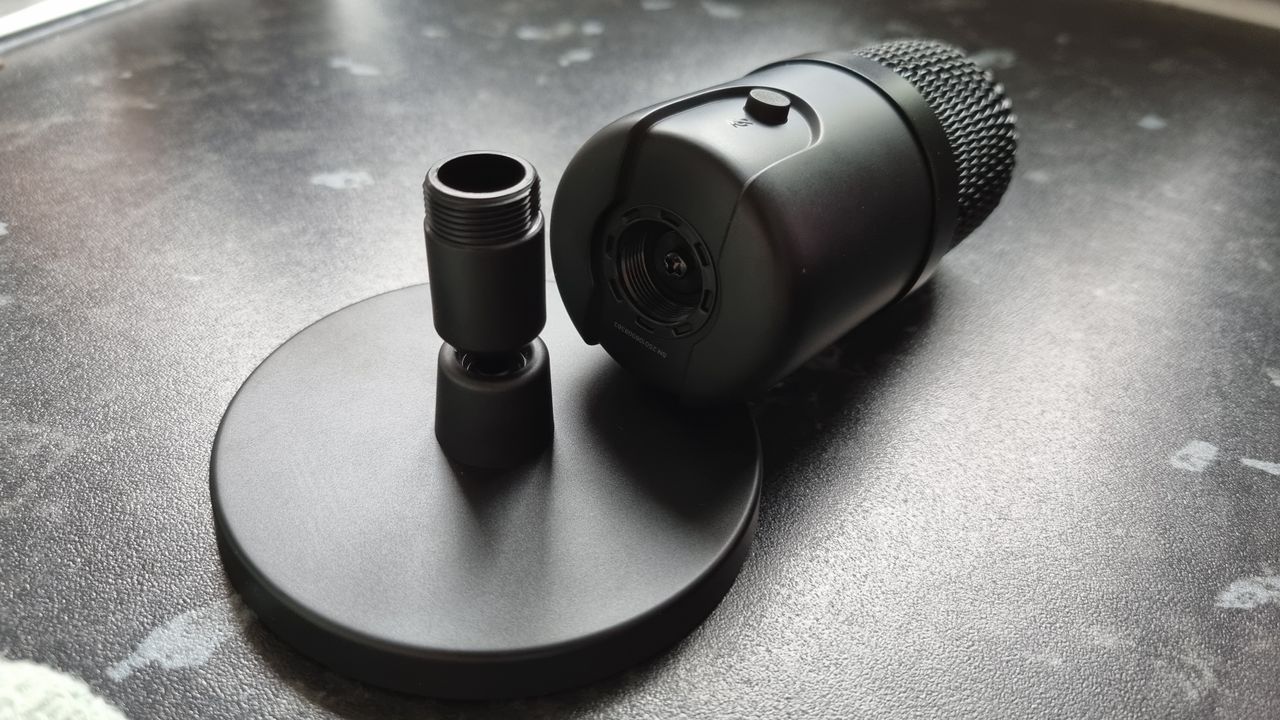 The Amazon Basics USB Condenser microphone detached from its stand, showing the socket connection underneath