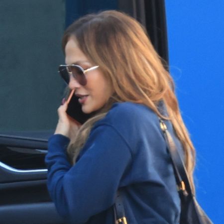 Jennifer lopez wears oversize sunglasses and a navy sweatshirt.