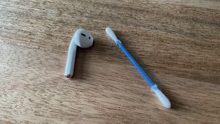 One AirPod earpice and a cotton bud