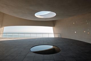 sun tower by open architecture, a curved, sloping, concrete tower, half open to the elements and looking out towards the sea