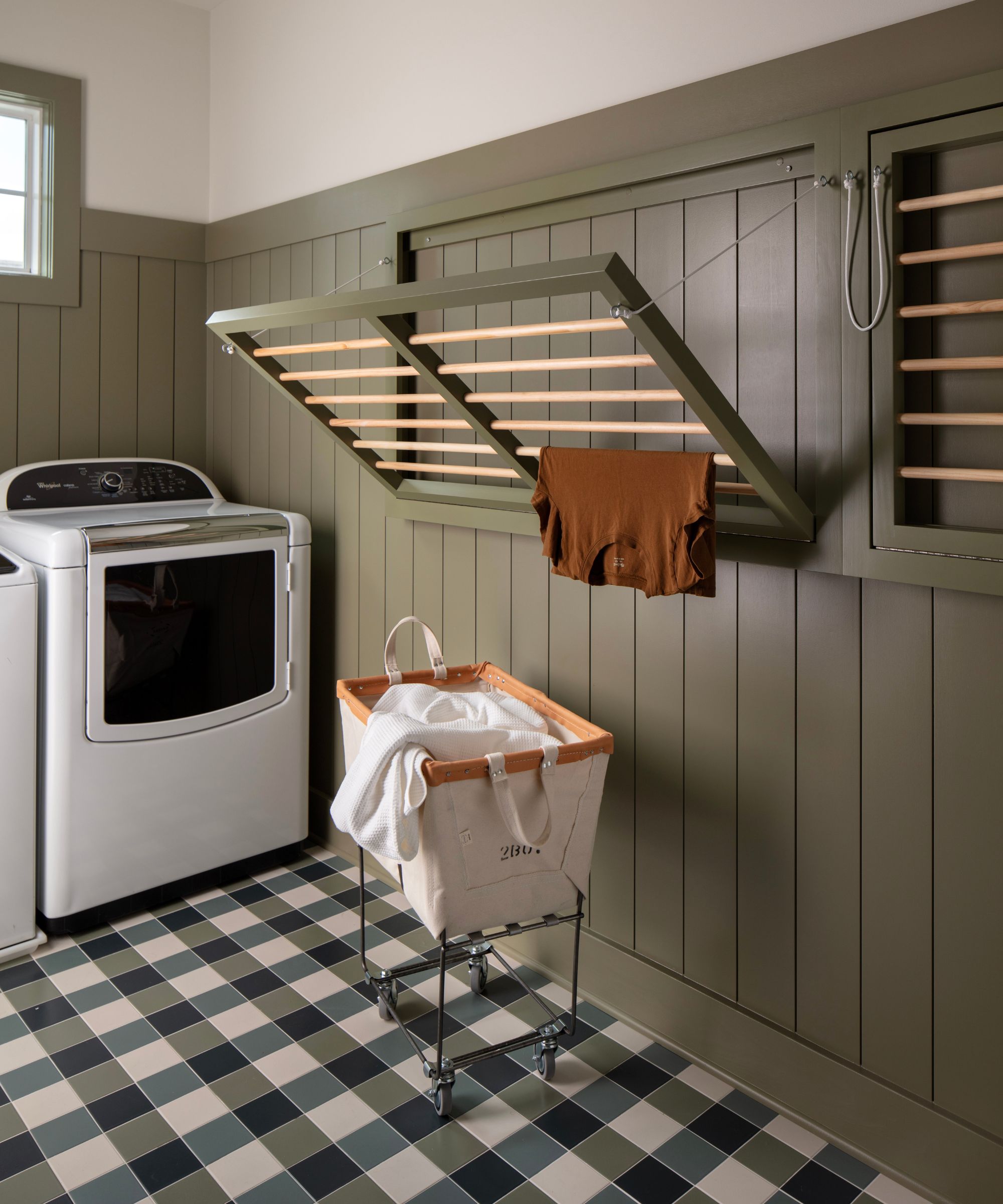 laundry room with green wall panelling, fold down dryers and a checked floor