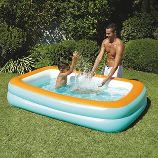 Little swimming pool toy in garden with men child