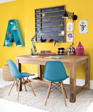 home office with gen z yellow wall and wooden desk with chair