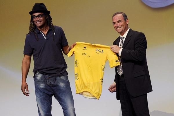 French tennis star Yannick Noah and French cycling legend Bernard Hinault with the Tour de France leader's jersey.