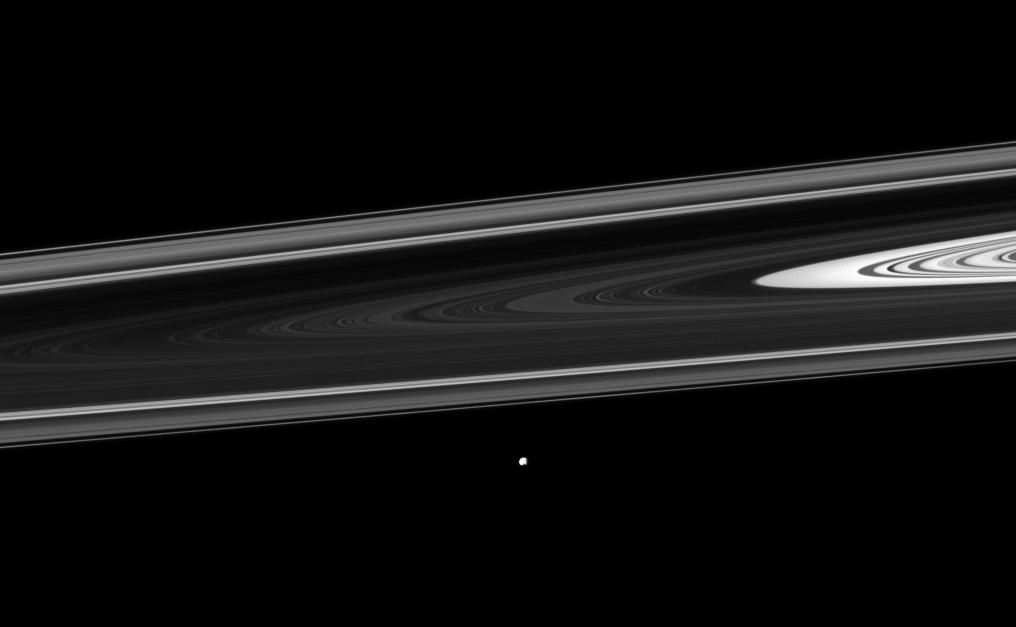The Cassini spacecraft watches Saturn's small moon Epimetheus orbiting beyond the planet's rings. The image was taken in visible light with the Cassini spacecraft narrow-angle camera on Dec. 30, 2011.