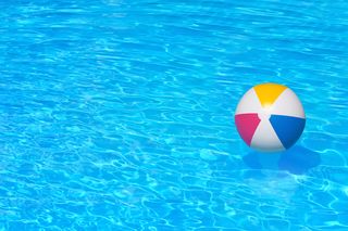 A beachball floats unattended in a swimming pool.