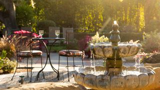 picture of water fountain in garden with bistro set