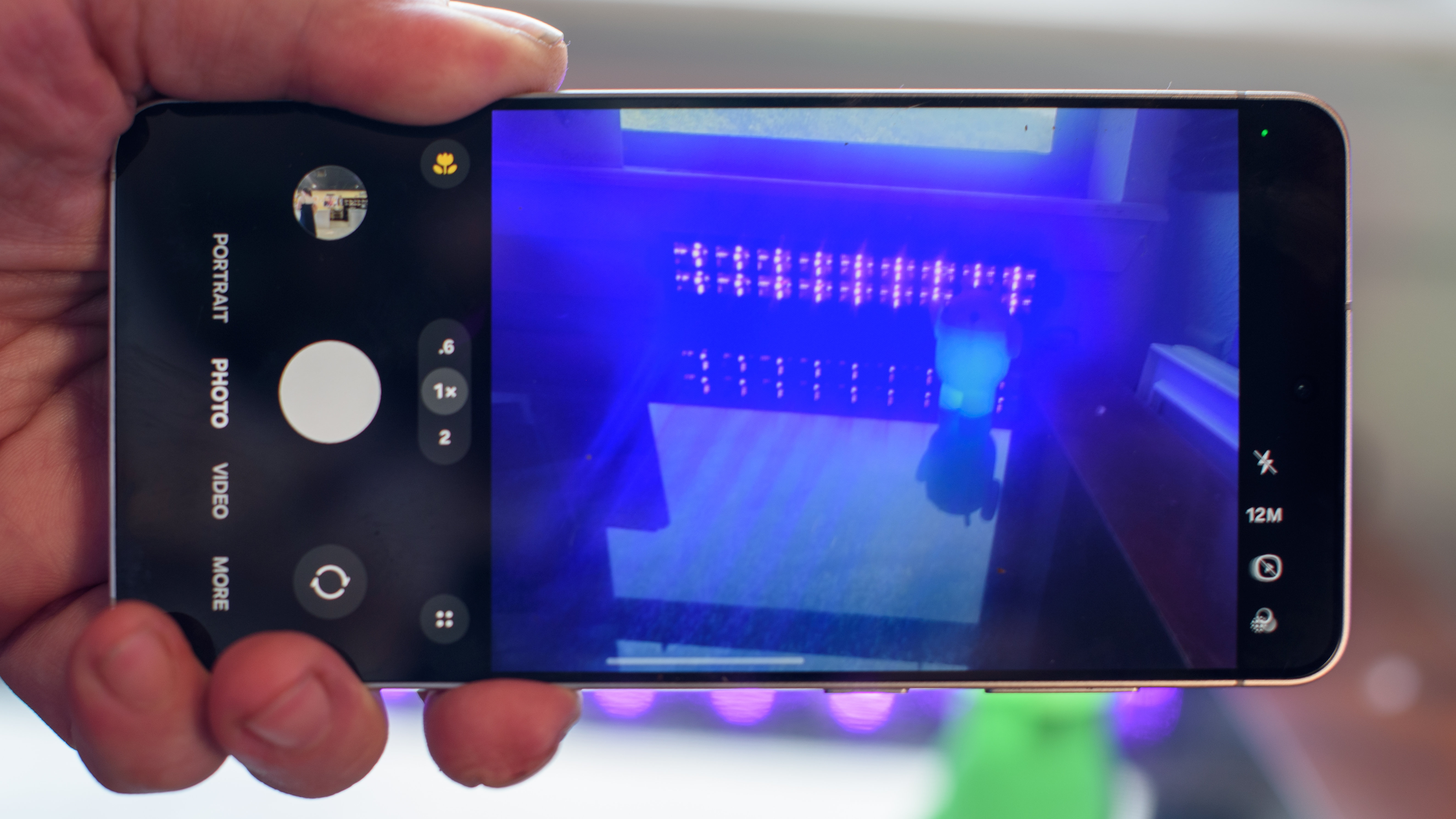 Samsung Galaxy S25 Edge showing the camera app focused on black lights and an Android figurine blurred in the background