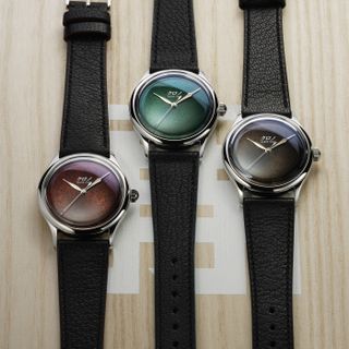 three minimalist watches, with red, green and black dials respectively