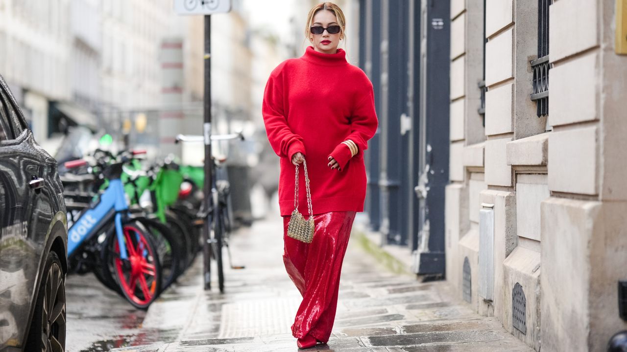 Merve Gorgotz wears sunglasses, a red oversized turtleneck pullover, a golden Rabanne metallic bag, red shiny glitter flowing lustrous skirt, pointed shoes, outside Georges Hobeika, during the Haute Couture Spring/Summer 2024 as part of Paris Fashion Week on January 22, 2024 in Paris, France. (Photo by Edward Berthelot/Getty Images)