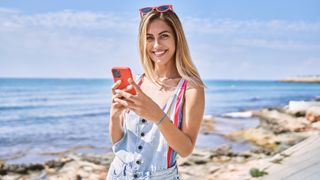 A woman looking at her smartphone at the beach