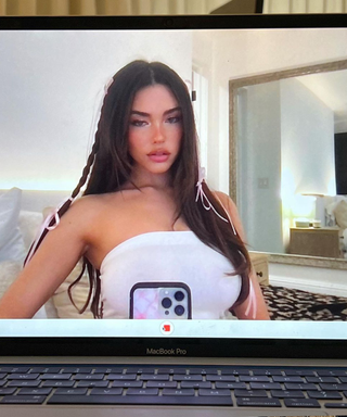 Madison Beer taking a photo of her laptop with a neutral bedroom in background