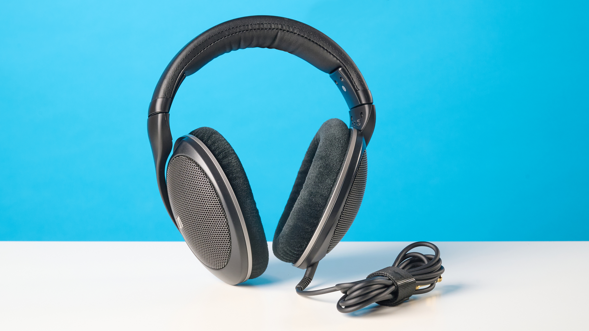 The Sennheiser HD 550 headphones on a stone surface with a blue background
