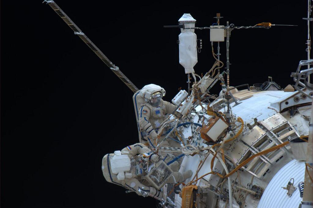 Cosmonauts Oleg Kotov, Expedition 38 commander, and flight engineer Sergey Ryazanskiy perform a spacewalk outside the International Space Station on Dec. 27, 2013. NASA astronaut Rick Mastracchio took this photo from inside the station.