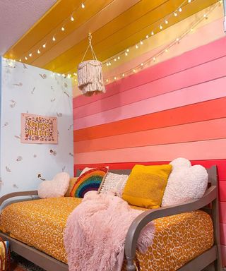 A girls' bedroom decorated with a DIY headboard made from wooden slats decorated with an assortment of wall paint colors