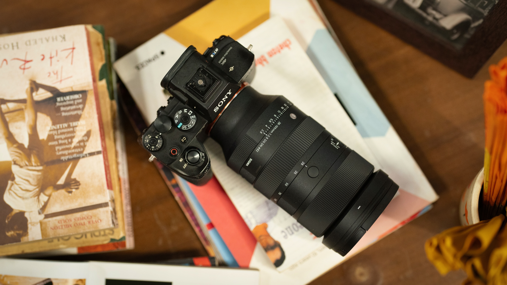 Sigma 28-105mm f/2.8 DG DN Art on a Sony camera, on a table covered in books