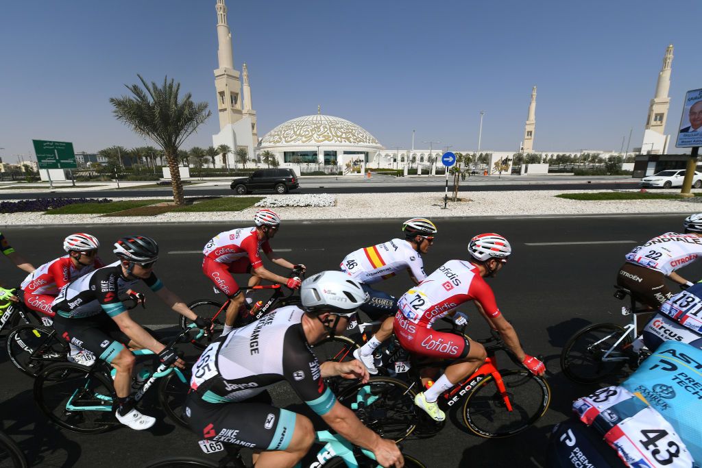 The UAE Tour peloton passes a mosque