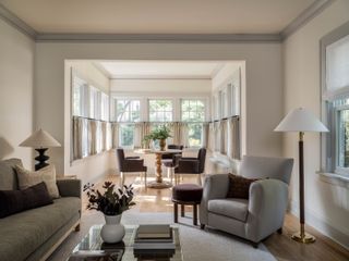 a living room with cafe curtains and grey sofa and armchair