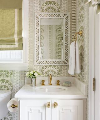 Bright, white powder room with sink, mirror, wallpaper and blind