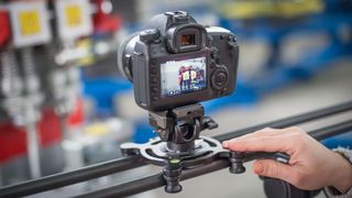 Videographer using camera slider, making video of business at factory