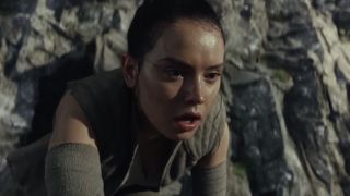 Rey on hands and knees on rocks in Star Wars The Last Jedi