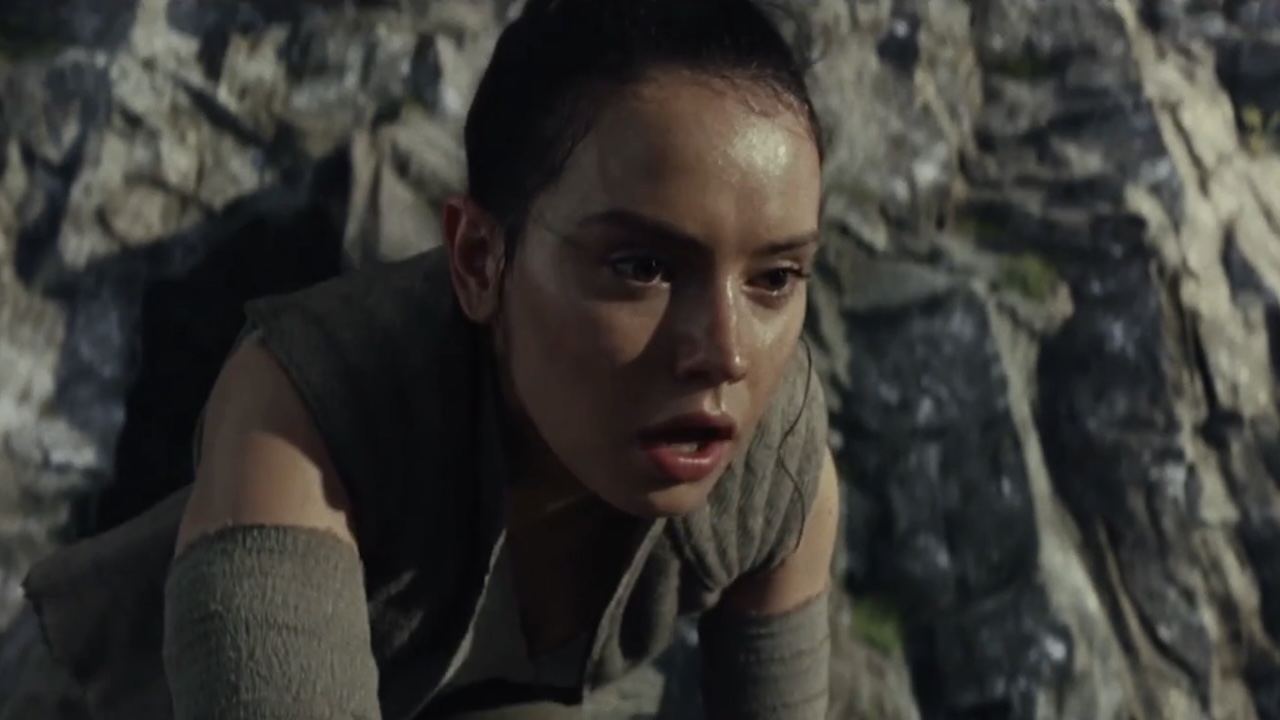 Rey on hands and knees on rocks in Star Wars The Last Jedi