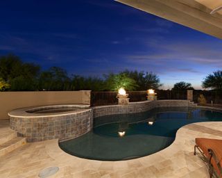 small pool with hot tub outdoors at night
