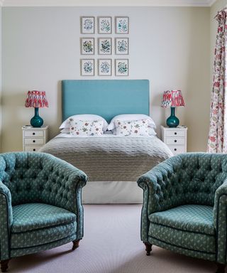 Luxury bedroom ideas illustrated in a neutral scheme with green armchairs and blue headboard.