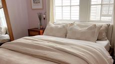 Double bed with white duvet set in lilac bedroom