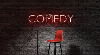 chair on stage in front of a 'comedy' sign