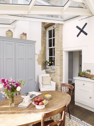 kitchen diner with blue cupboards and flowers