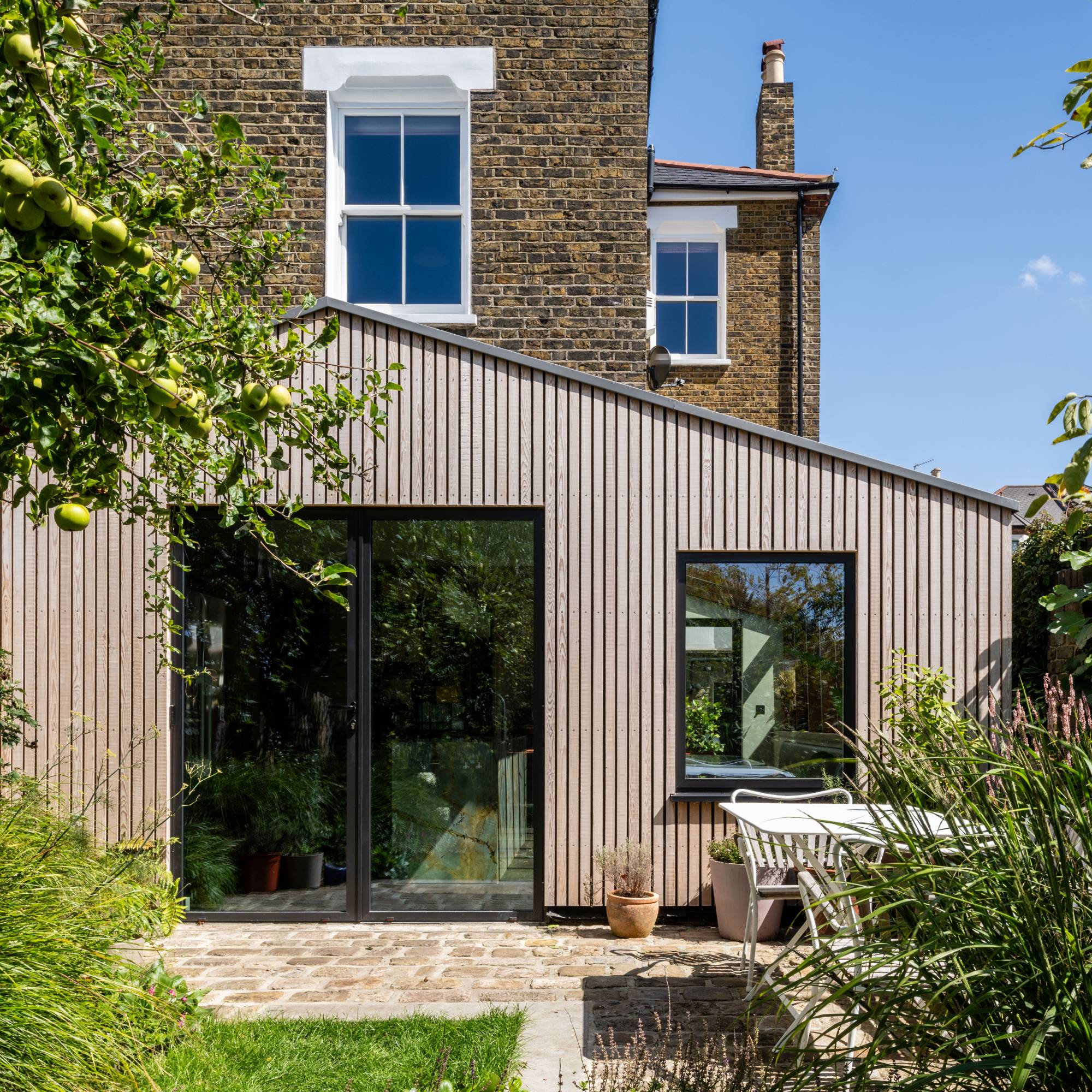 single storey house extension with timber vertical cladding and sliding doors