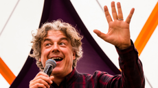 Alan Davies waving to audience while on stage