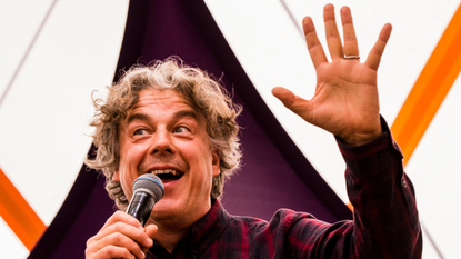 Alan Davies waving to audience while on stage