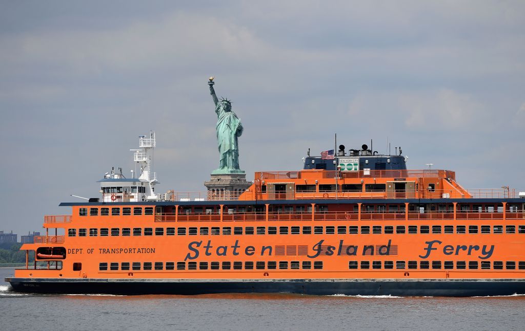 The Staten Island ferry passes in front of the Statue Of Liberty