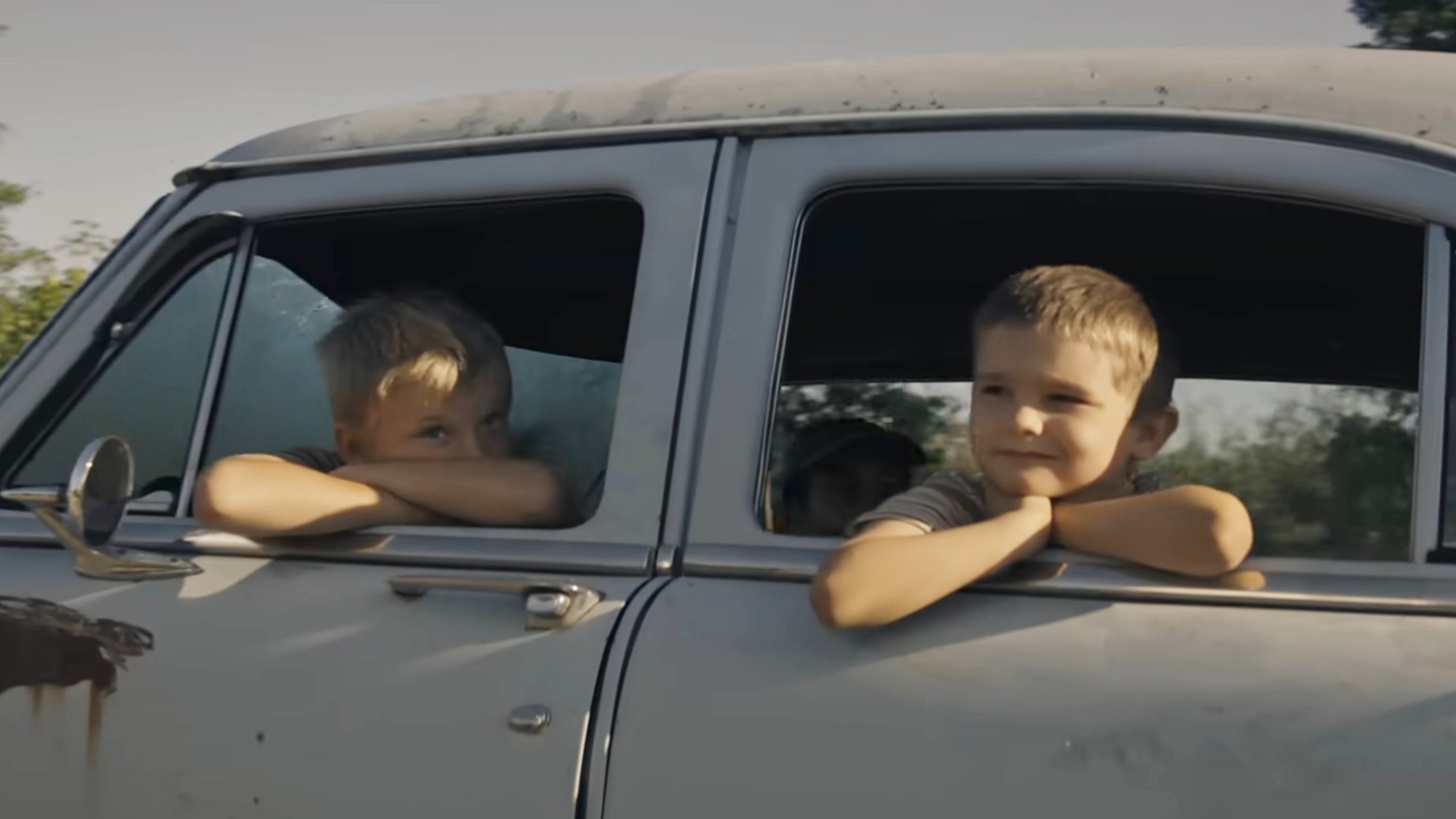 Two boys watching outside a car in The Long Walk