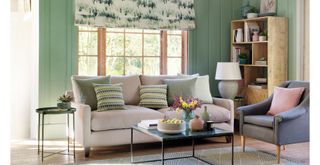 Green living room with neutral linen sofa to show how color can bring positive energy into your home