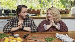 (L to R) Ben Falcone as Clark Thompson, Melissa McCarthy as Amily Luck stare at each other while they're in the praying position in episode 107 of God’s Favorite Idiot